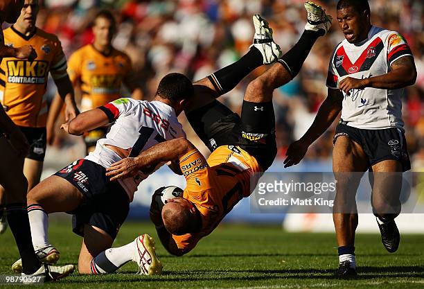 Todd Payton of the Tigers is tackled in a dangerous position by Nate Myles of the Roosters during the round eight NRL match between the Wests Tigers...