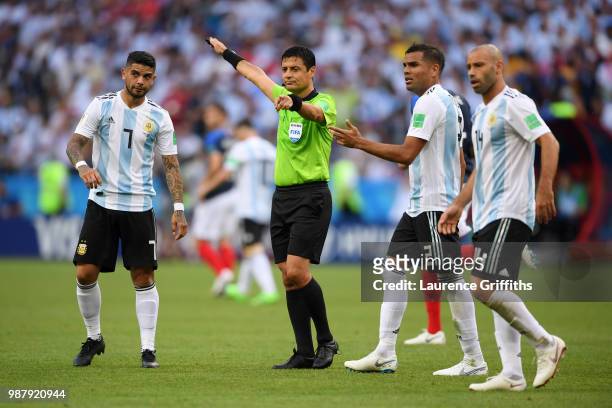 Referee Alireza Faghani gestures while Ever Banega of Argentina looks on during the 2018 FIFA World Cup Russia Round of 16 match between France and...