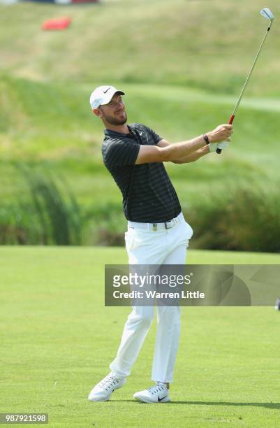 Chris Wood of England plays his second shot into the 10th green during the third round of the HNA Open de France at Le Golf National on June 30, 2018...