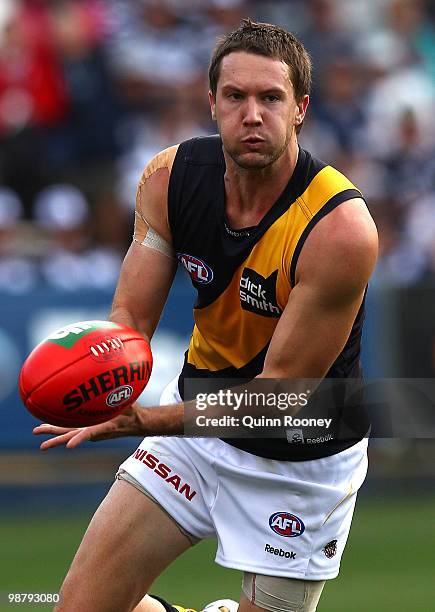 Will Thursfield of the Tigers handballs during the round six AFL match between the Geelong Cats and the Richmond Tigers at Skilled Stadium on May 2,...