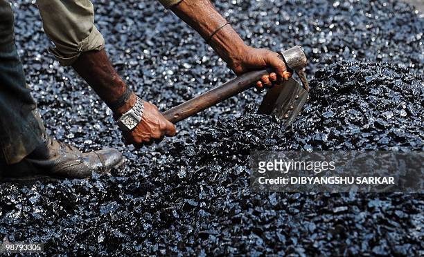 Migrant Indian labourer works on a road construction site in Bangalore on April 30, 2010. The elevation of Bangalore as the information technology...