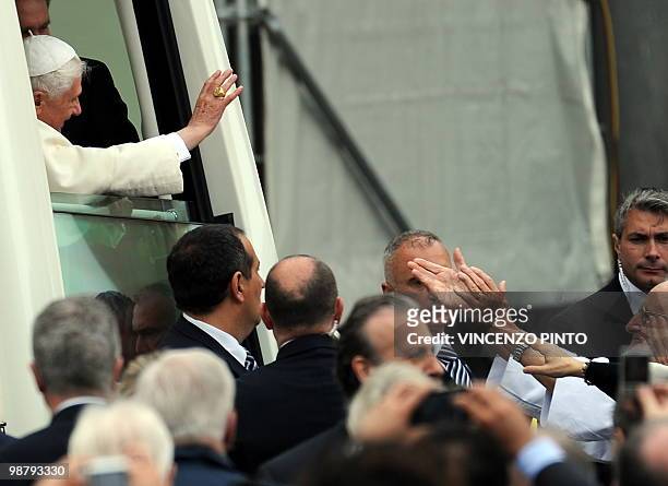 Pope Benedict XVI waves to faithfuls from the popemobile as he arrives to celebrate a mass at San Carlo square in central Turin on May 2, 2010. Pope...