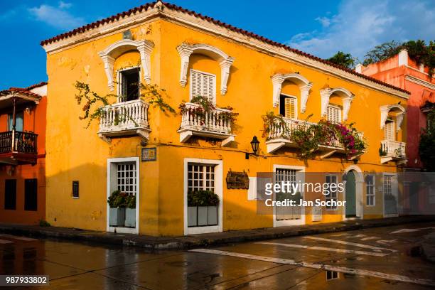 Spanish colonial house, decorated with flowers, is seen reflected on the pavement in the walled city on December 12, 2017 in Cartagena, Colombia....