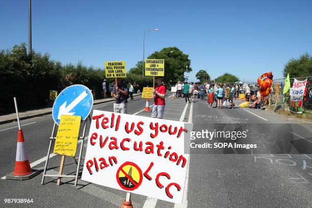 Two local Anti Frack Protesters hold placards on a main road to highlight the claims that Fracking causes contamination of water, land a the food...