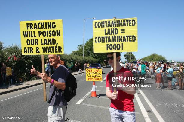 Two local Anti Frack Protesters hold placards on a main road to highlight the claims that Fracking causes contamination of water, air, land and the...