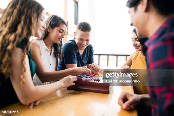 young people enjoyig time with a boardgame - board game stock pictures, royalty-free photos & images