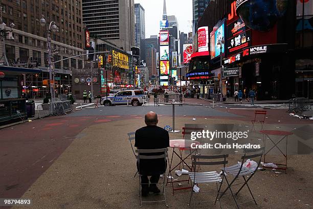 Man watches from tables in Times Square near sunrise a few blocks from where a crude car bomb had been parked at 45th Street and 7th Avenue May 2,...