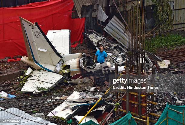 Officials examine the crash site where a chartered plane crashed into an under-construction site in Ghatkopar area, on June 29, 2018 in Mumbai,...