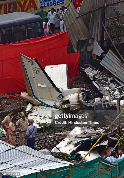 Police officials examine a crash site after a chartered plane crash yesterday afternoon in Mumbai's Ghatkopar area, on June 29, 2018 in Mumbai,...