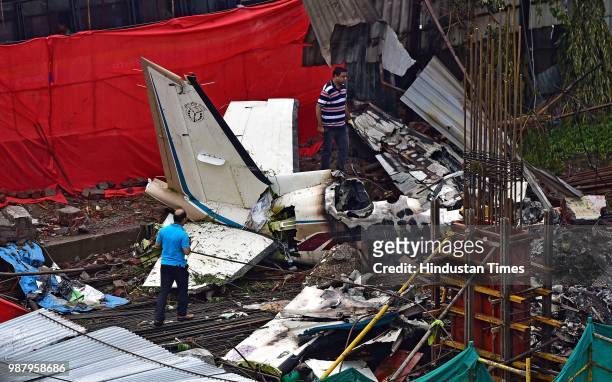 Officials examine the crash site where a chartered plane crashed into an under-construction site in Ghatkopar area, on June 29, 2018 in Mumbai,...