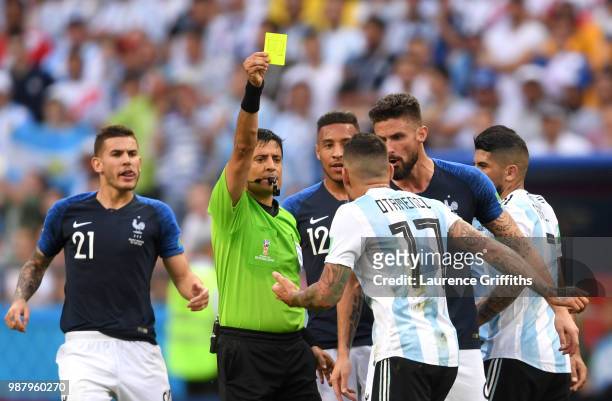 Nicolas Otamendi of Argentina is shown a yellow card by referee Alireza Faghani during the 2018 FIFA World Cup Russia Round of 16 match between...
