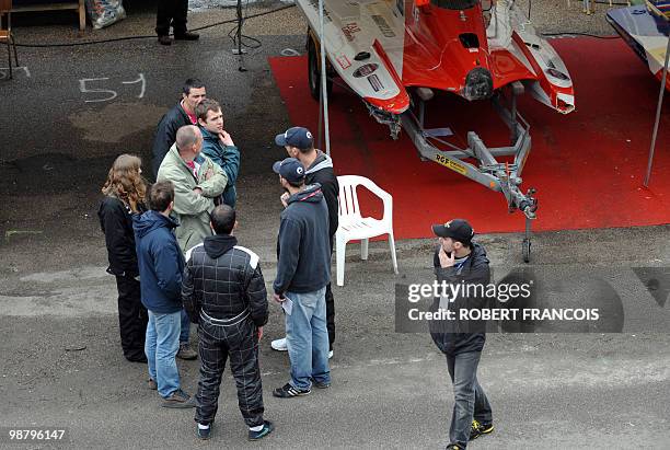 People gather in front of the garage of the boat which crashed into a zodiac, killing a Gendarme, after the start of the 47th edition of Rouen's 24...