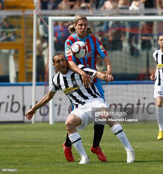 Maximiliano Maxi Lopez of Catania Calcio competes for the ball with Giorgio Chiellini of Juventus FC during the Serie A match between Catania and...