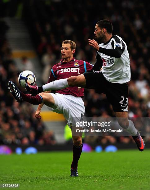 Jonathan Spector of West Ham United battles with Clint Dempsey of Fulham during the Barclays Premier League match between Fulham and West Ham United...