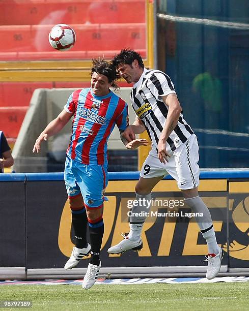 Pablo Alvarez of Catania Calcio competes for the ball with Vincenzo Iaquinta of Juventus FC during the Serie A match between Catania and Juventus at...