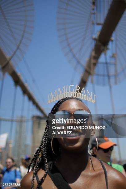 Demonstrators cross the Brooklyn Bridge as they march against the separation of immigrant families, on June 30, 2018 in New York. - Demonstrations...