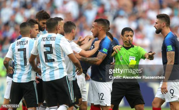 Match referee Alireza Faghani separates players as Corentin Tolisso of France confronts Argentina players during the 2018 FIFA World Cup Russia Round...