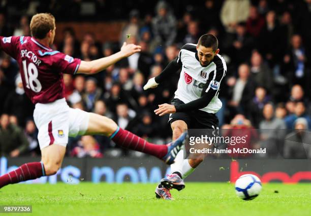 Clint Dempsey of Fulham beats Jonathan Spector of West Ham United to score their first goal during the Barclays Premier League match between Fulham...