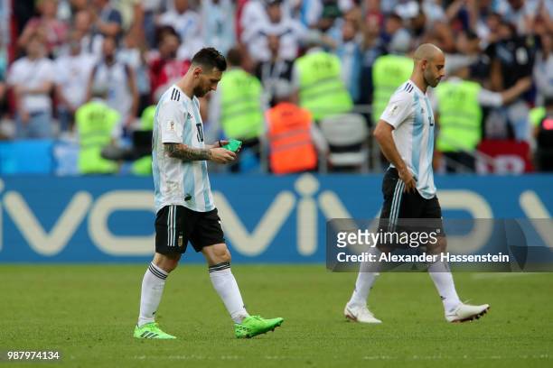 Lionel Messi of Argentina removes his captain's armband and looks dejected following the 2018 FIFA World Cup Russia Round of 16 match between France...