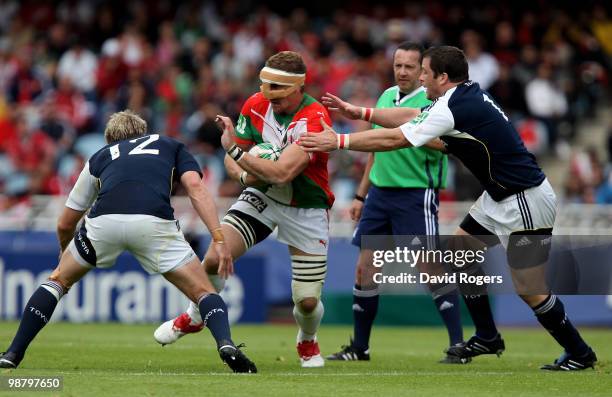 Imanol Harinordoquy of Biarritz, wearing a face protector, takes on Jean de Viliers and Marcus Horan during the Heineken Cup semi final match between...