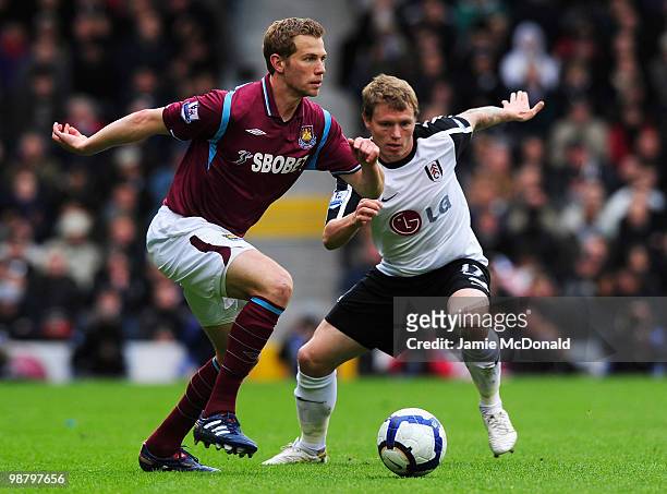 Jonathan Spector of West Ham United holds off Bjorn Helge Riise of Fulham during the Barclays Premier League match between Fulham and West Ham United...