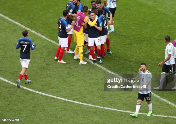 Lionel Messi of Argentina looks dejected while France players celebrate victory following the 2018 FIFA World Cup Russia Round of 16 match between...