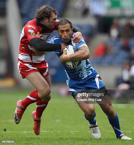 Paula Whatuira of Huddersfield Giants is tackled by Steffan Marsh of Wigan Warriors during the Engage Rugby Super League Magic Weekend match between...