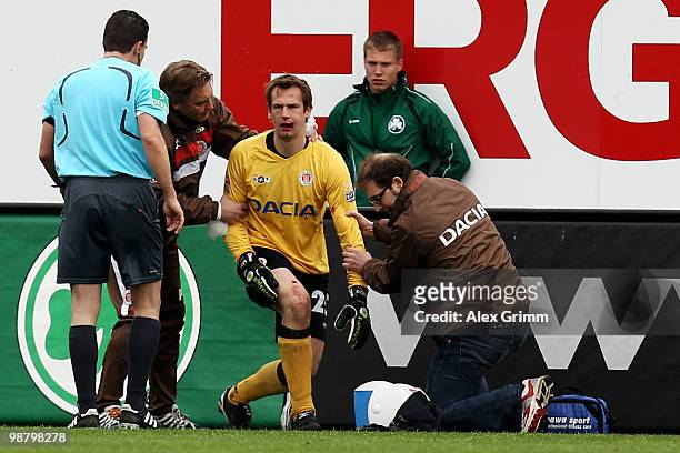 Goalkeeper Mathias Hain of St. Pauli receives treatment before being substituted during the Second Bundesliga match between SpVgg Greuther Fuerth and...