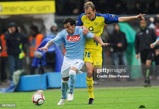 Ezequiel Lavezzi of Napoli competes with Luca Rigoni of Chievo during the Serie A match between Chievo and Napoli at Stadio Marc'Antonio Bentegodi on...