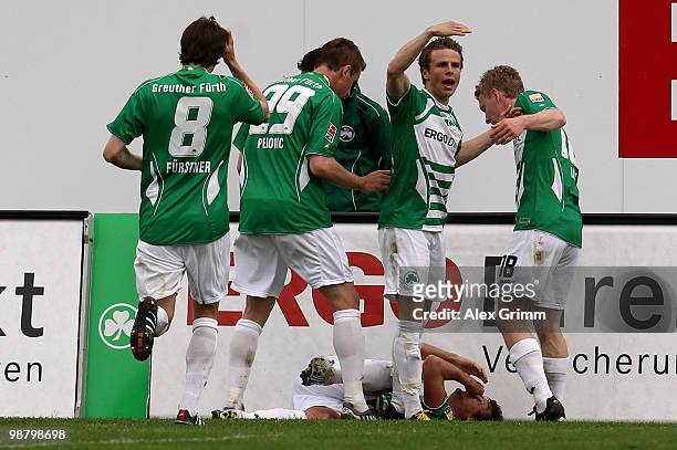 Injured Christopher Noethe of Greuther Fuerth is surrounded by team mates after he scored his team's first goal during the Second Bundesliga match...