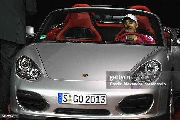 Justine Henin of Belgium drives with her winners present, a Porsche Boxter Spyder after winning her final match against Samantha Stosur of Australia...