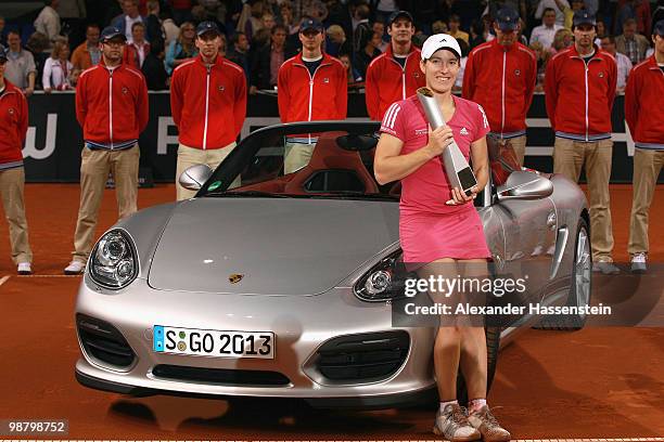 Justine Henin of Belgium poses with the winners present, a Porsche Boxter Spyder after winning her final match against Samantha Stosur of Australia...