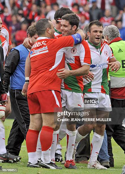 Biarritz' coach Jean-Michel Gonzalez congratulates French scrum-half Dimitri Yachvili as Arnaud Mignardi walks at the end of the European cup rugby...