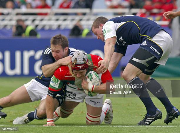 Biarritz' center Magnus Lund is stopped by Munster's Denis Hurley and Tomas O'Leary during the European cup rugby union semi-final match Biarritz vs....