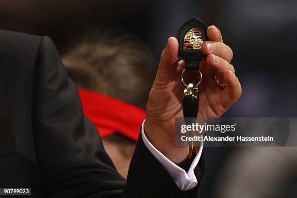 Michael Macht, chief executive officer of Porsche AG, holds a Porsche Boxter Sypder key at the final day of the WTA Porsche Tennis Grand Prix...