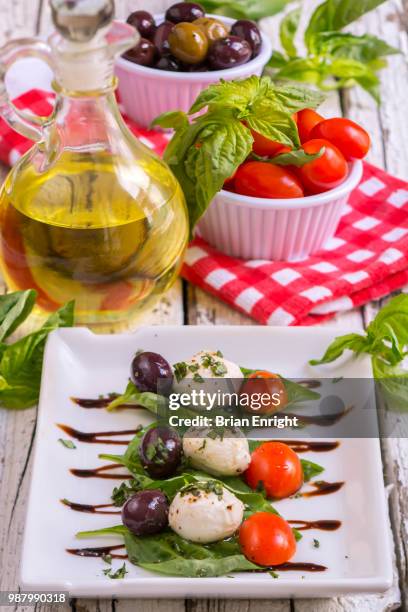 caprese salad with olive oil and balsamic vinegar on a white plate and a rustic wooden table - white vinegar stock pictures, royalty-free photos & images