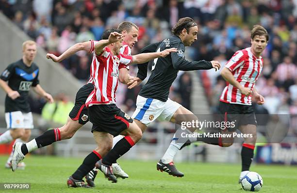 Dimitar Berbatov of Manchester United clashes with David Meyler and Steed Malbranque of Sunderland during the Barclays Premier League match between...