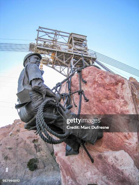 view from below of a sculpture in memory of those who built the hoover dam in nevada during day - hoover dam statues stock pictures, royalty-free photos & images