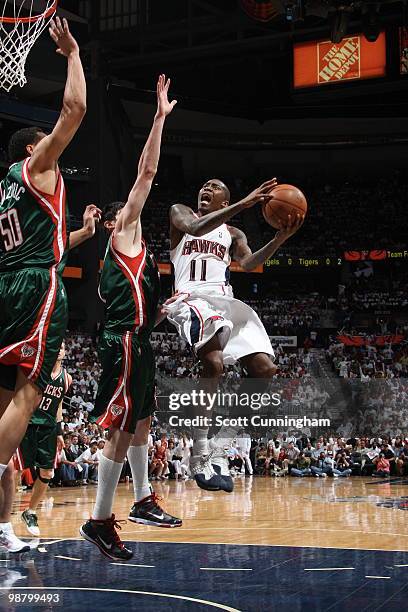 Jamal Crawford of the Atlanta Hawks puts up a shot against Ersan Ilyasova of the Milwaukee Bucks in Game Seven of the Eastern Conference...