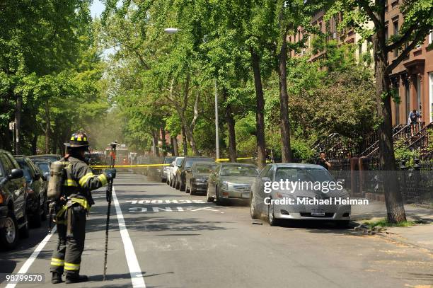 Firefighter stands in front of two smoking cars on May 2, 2010 in the Carroll Gardens neighborhood of the Brooklyn borough of New York City. A series...