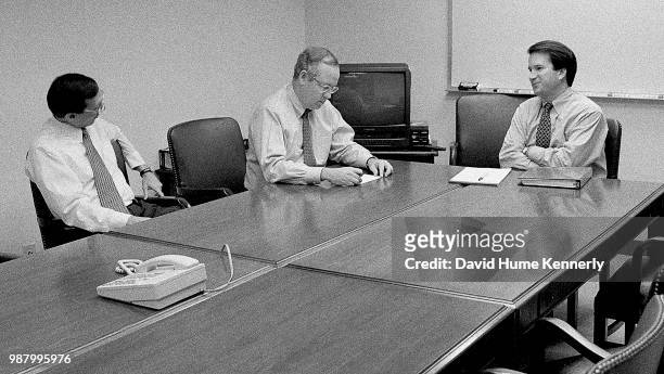 Independent Counsel Kenneth Starr, center, talks with Deputy Independent Counsel John Bates, left, and aide Brett Kavanaugh, right, and another...
