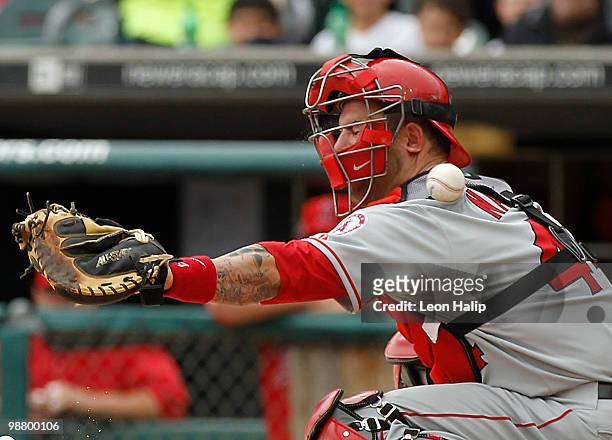 Mike Napoli of the Los Angeles Angels of Anaheim reacts after getting hit in the mask with a foul tip off the bat of Miguel Cabrere of the Detroit...