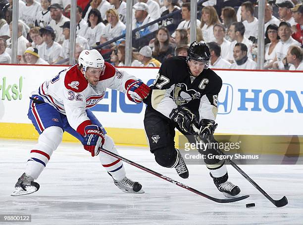 Sidney Crosby of the Pittsburgh Penguins moves the puck up ice in front of Travis Moen of the Montreal Canadiens in Game Two of the Eastern...