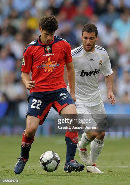 Roberto Esquiroz of Osasuna duels for the ball with Gonzalo Higuain of Real Madrid during the La Liga match between Real Madrid and Osasuna at the...
