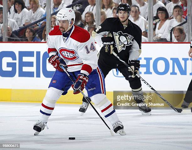 Tomas Plekanec of the Montreal Canadiens moves the puck up ice in front of Chris Kunitz of the Pittsburgh Penguins in Game Two of the Eastern...