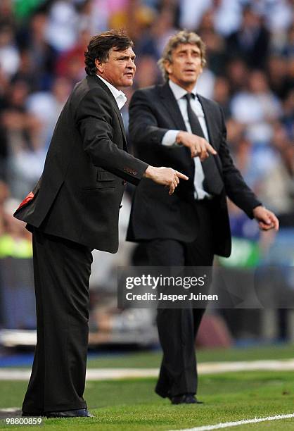 Head coach Jose Antonio Camacho of Osasuna gestures to his players backdropped by head coach Manuel Pellegrini of Real during the La Liga match...