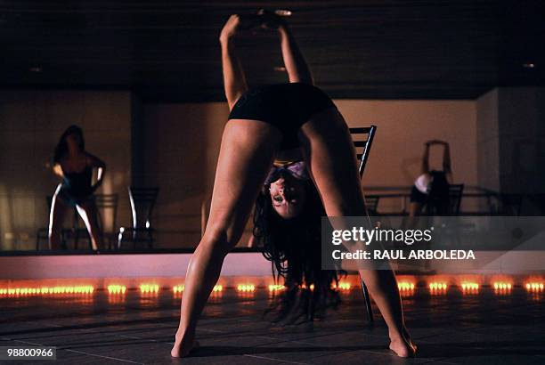 Group of young women stretch before performing their routine at a Pole Dance academy in Medellin, Antioquia department, Colombia on April 27, 2010....