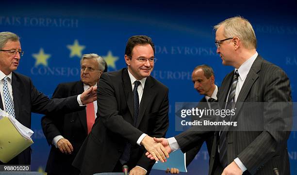 George Papaconstantinou, Greece's finance minister, center, shakes hands with Olli Rehn, European Union economic and monetary affairs commissioner,...