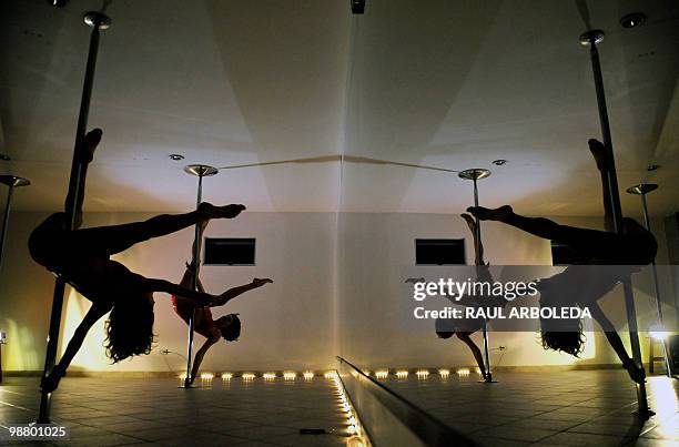 Monica Sierra and Zully Ochoa perform their pole dancing routine at a Pole Dance academy in Medellin, Antioquia department, Colombia on April 27,...