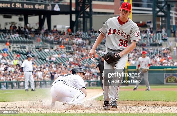 Scott Sizemore of the Detroit Tigers scores on a wild pitch in the fifth inning as Jered Weaver of the Los Angeles Angels of Anaheim attempts to...